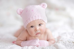 newborn baby girl in pink knitted bear hat
