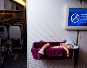 Small two year old baby girl sleep in a bassinet on a airplane