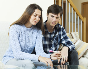 worried couple with pregnancy test